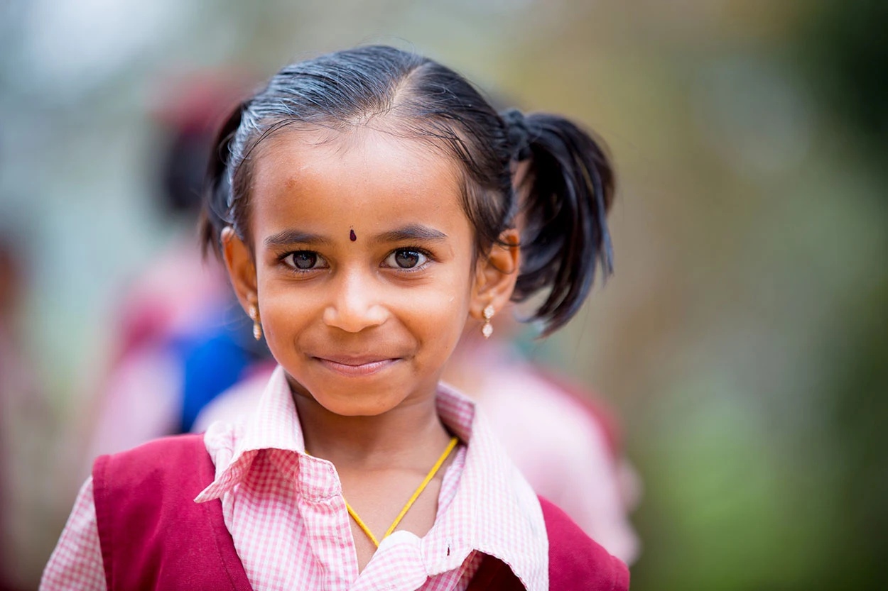 Smiling girl child from free rural schools run by Care For Children